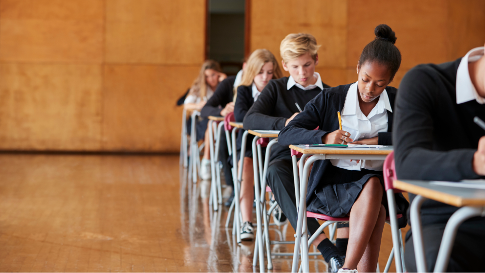 Secondary school students sitting an exam in a large hall