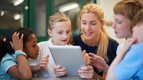 A teacher uses a tablet to teach her class